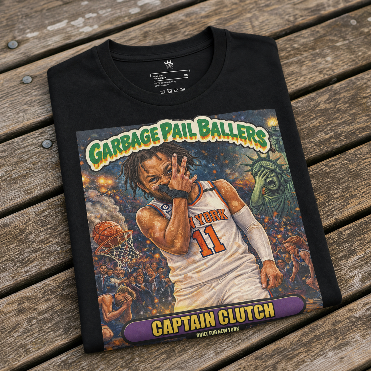 Front view of black Vintage Hardwood Classics Captain Clutch T-Shirt featuring a Garbage Pail Ballers basketball graphic and New York cityscape on wood bench – Rebel P Customs