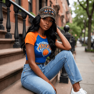 Woman wearing camouflage New York rhinestone baseball hat with matching Knicks shirt on city steps - Rebel P Customs