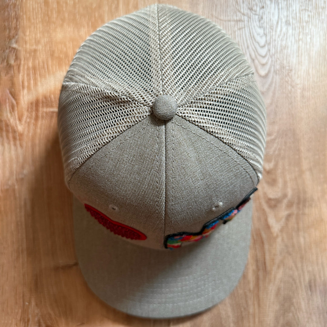 Beige cap with a red heart and colorful 'NY' on a wooden surface