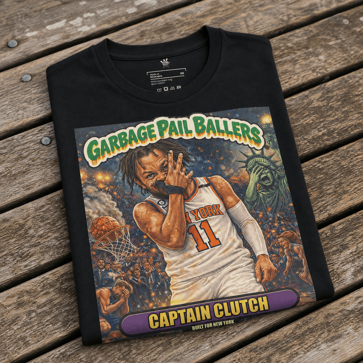 Front view of black Vintage Hardwood Classics Captain Clutch T-Shirt featuring a Garbage Pail Ballers basketball graphic and New York cityscape on wood bench – Rebel P Customs